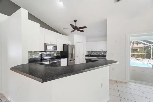 a kitchen with stainless steel appliances granite countertop a sink dishwasher and a stove with wooden floor
