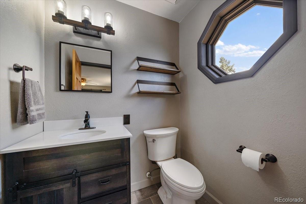 32482 Lodgepole Drive Evergreen, CO 80439 - Photo 12 of 40 a bathroom with a toilet a sink and mirror