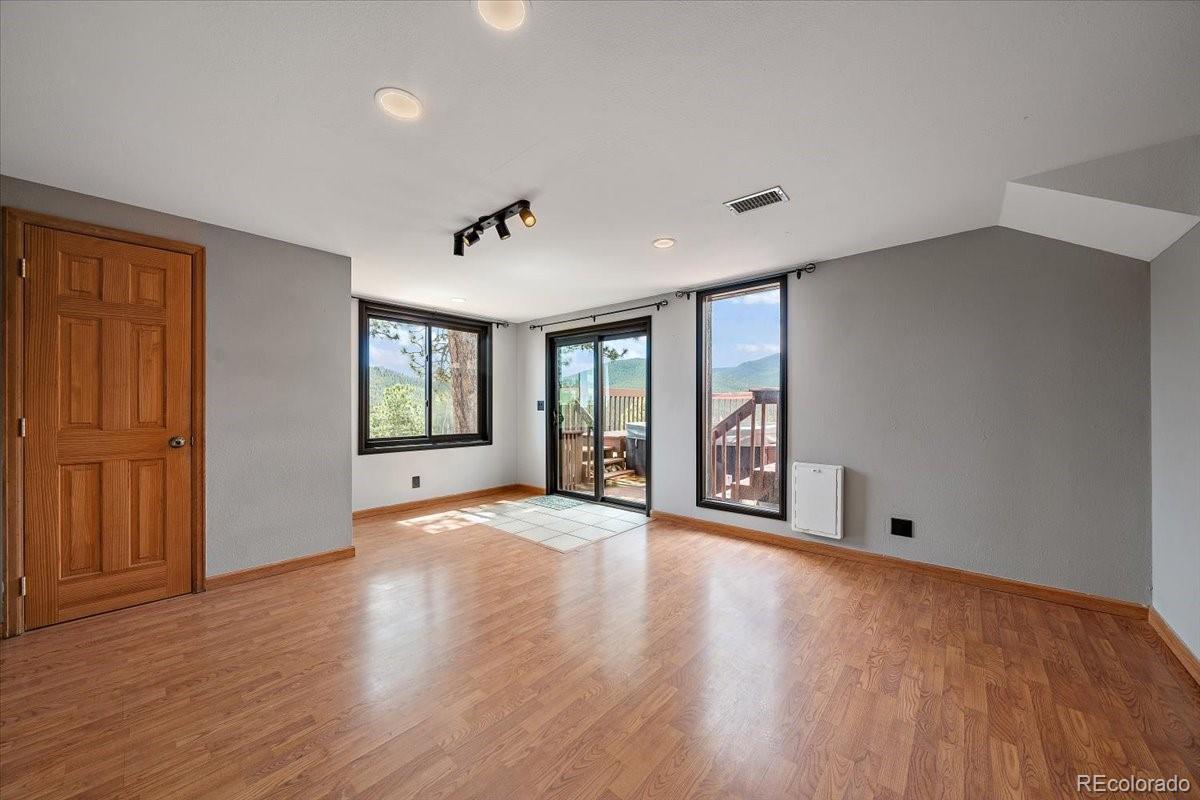 32482 Lodgepole Drive Evergreen, CO 80439 - Photo 24 of 40 a view of an empty room with window and wooden floor