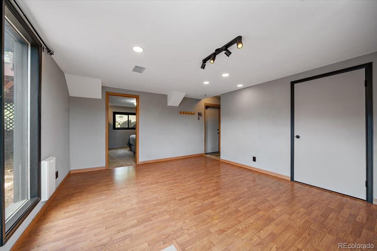 32482 Lodgepole Drive Evergreen, CO 80439 - Photo 25 of 40 a view of an empty room with wooden floor and a window