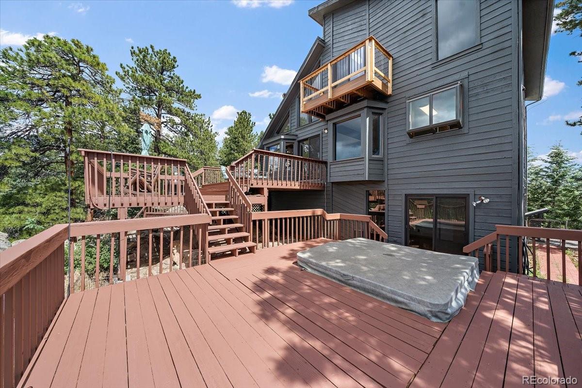 32482 Lodgepole Drive Evergreen, CO 80439 - Photo 32 of 40 a view of a house with wooden deck and furniture