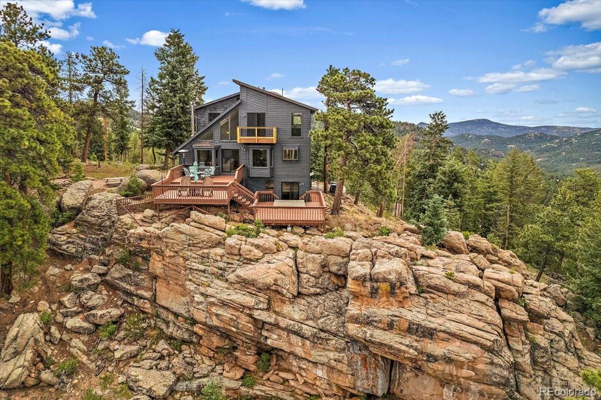 32482 Lodgepole Drive Evergreen, CO 80439 - Photo 33 of 40 a view of a house with a yard and sitting area