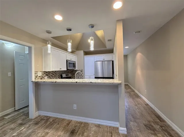 a kitchen with stainless steel appliances granite countertop a sink a stove and a refrigerator