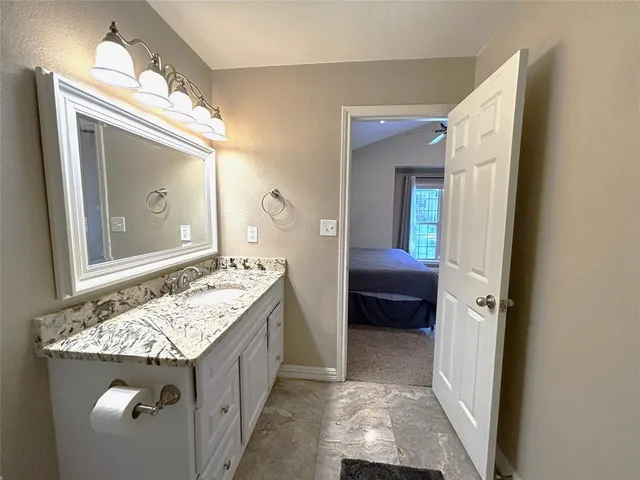 a bathroom with a granite countertop sink and a mirror
