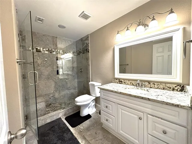 a bathroom with a sink toilet a mirror and shower