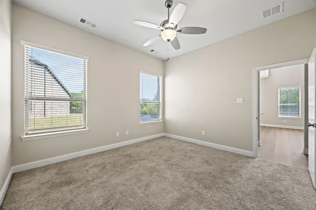 a view of an empty room with a ceiling fan