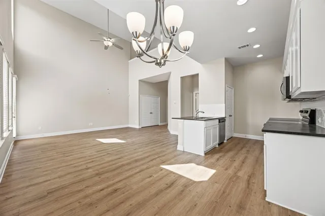 a view of a kitchen with granite countertop wooden floor stainless steel appliances and cabinets