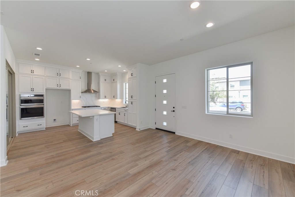 162 Pattern Irvine, CA 92618 - Photo 8 of 39 a open kitchen with kitchen island a sink dishwasher a stove and a refrigerator with wooden floor