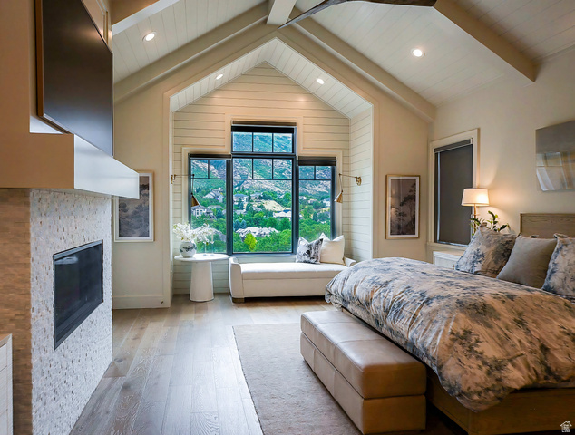 3 Carriagewood Cove, Unit 1088 Sandy, UT 84092 - Photo 28 of 79 Vaulted ceiling bedroom featuring a floor-to-ceiling window, an integrated window seat, wood-finish flooring, a stone-clad fireplace with a mounted television, and recessed lighting