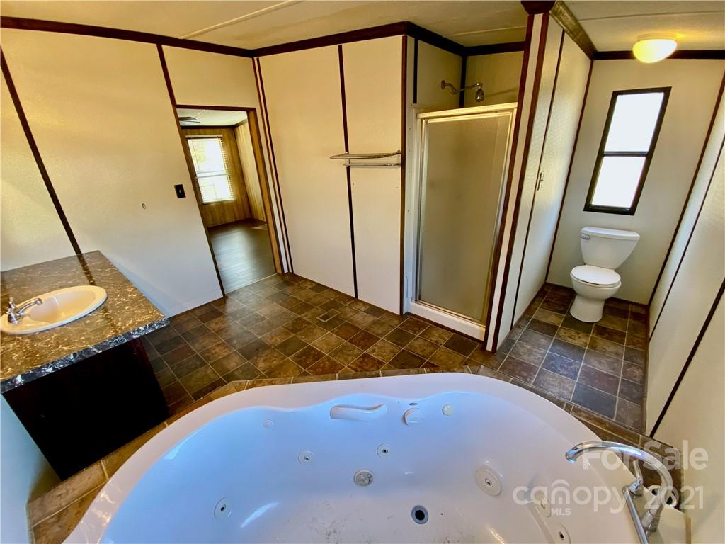 6102 Bill Sain Road Vale, NC 28168 - Photo 4 of 13 a bathroom with a tub sink and mirror