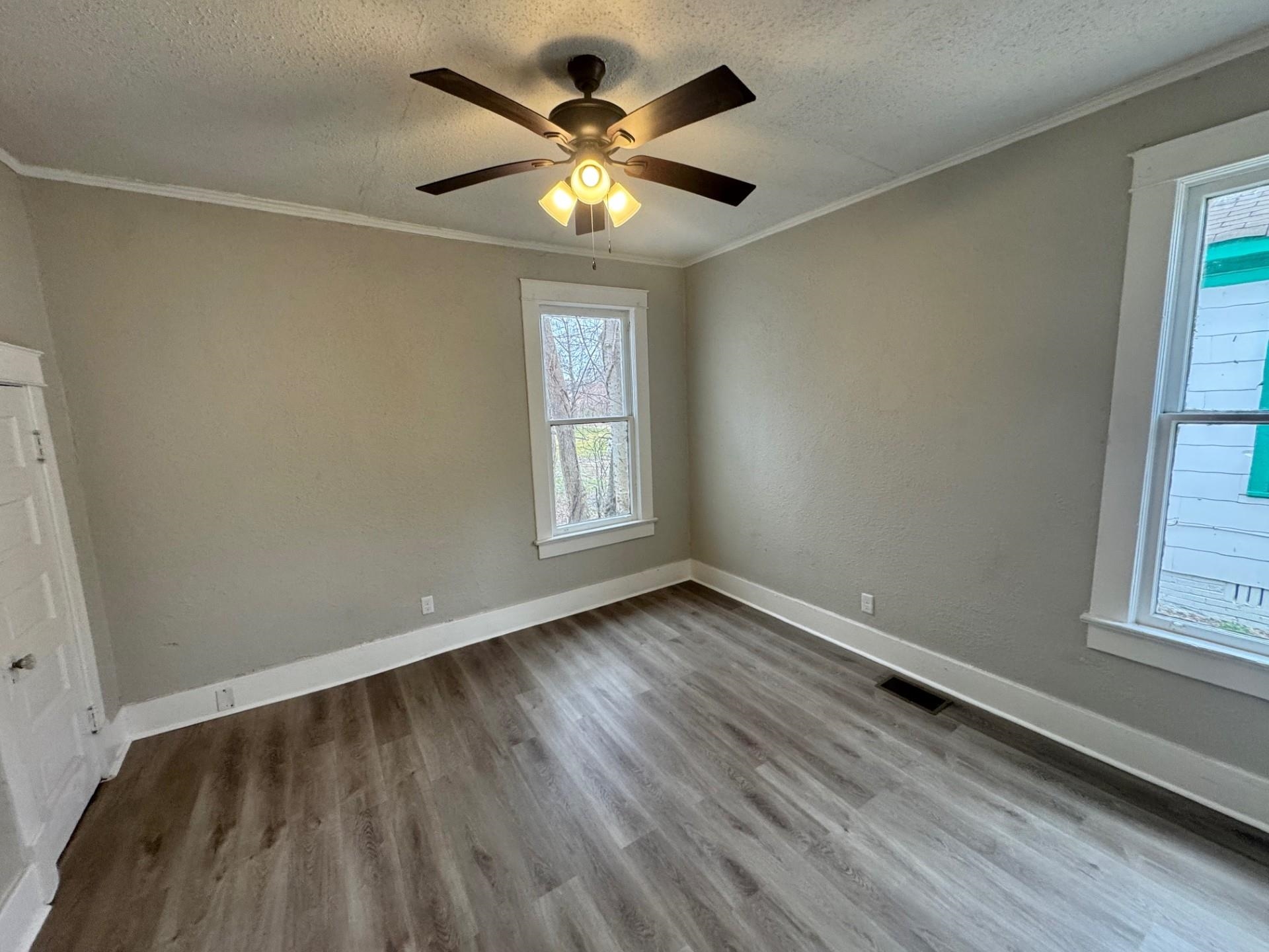 879 Tully Street Memphis, TN 38107 - Photo 11 of 12 an empty room with wooden floor and windows