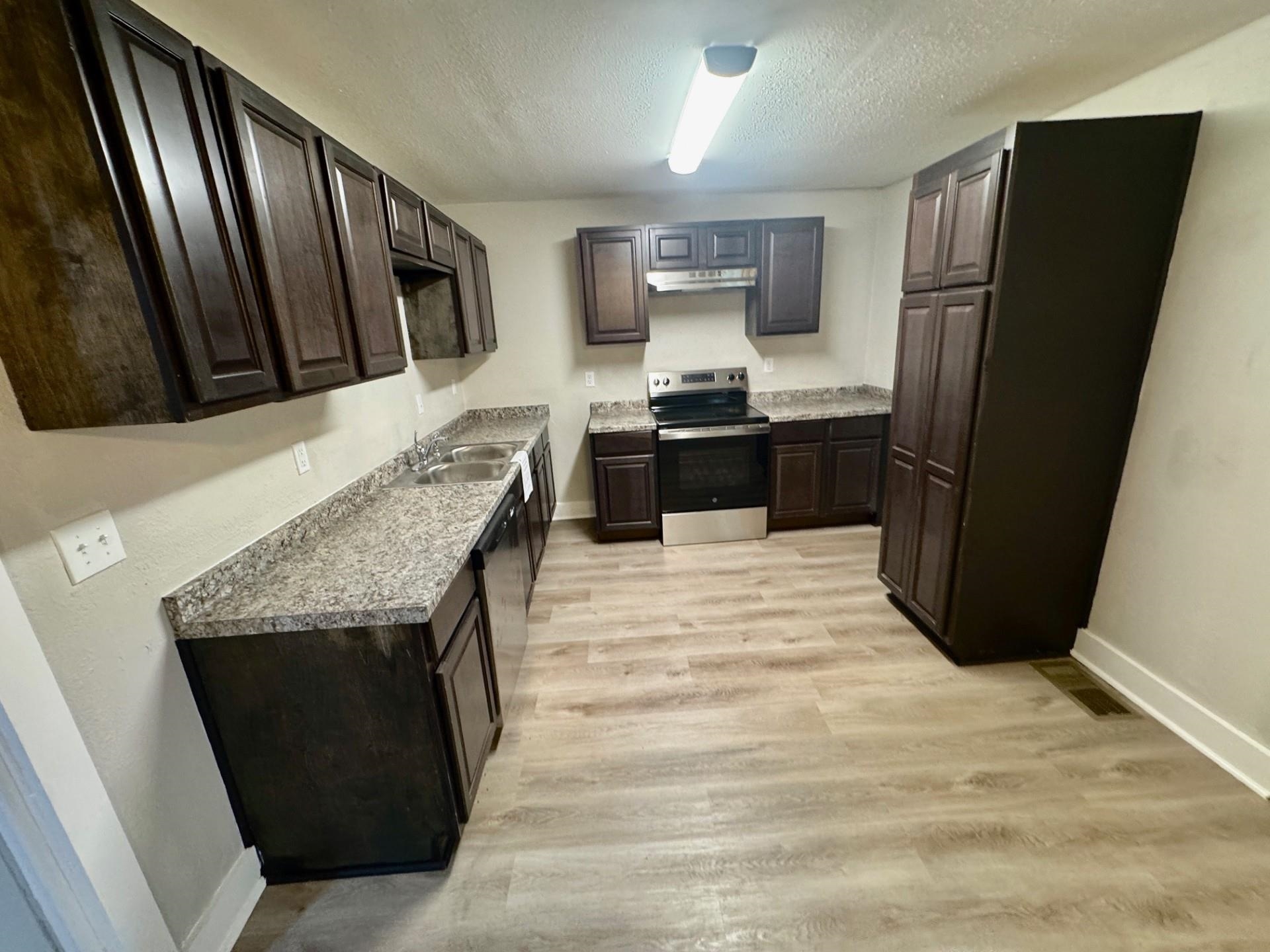 879 Tully Street Memphis, TN 38107 - Photo 5 of 12 a kitchen with granite countertop a refrigerator and a sink