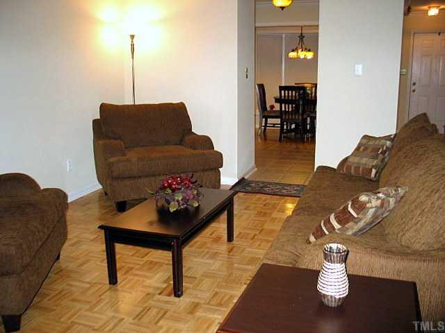 2951 Faversham Place Raleigh, NC 27604 - Photo 12 of 12 You can see the spacious open floorplan from this view of the living room. Notice the parque wood flooring and ceramic tiles. Also leads to private patio surrounded by lush greenery and trees. Living Room