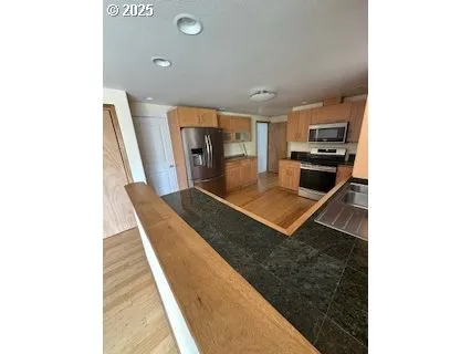 a kitchen with kitchen island a counter top space a stove and cabinets