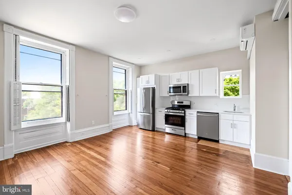 a kitchen with granite countertop a refrigerator and a stove top oven