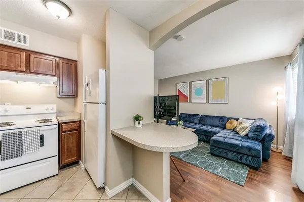 a living room with furniture a refrigerator and a stove
