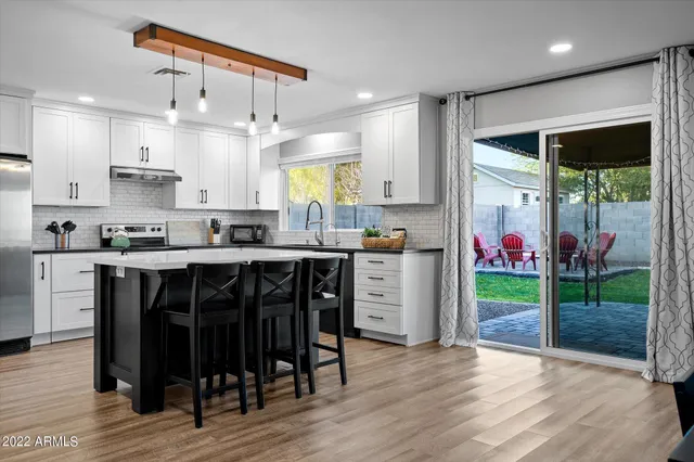 a kitchen with kitchen island granite countertop a table and chairs in it