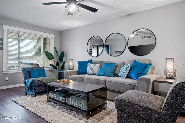 a living room with furniture potted plant and a large window