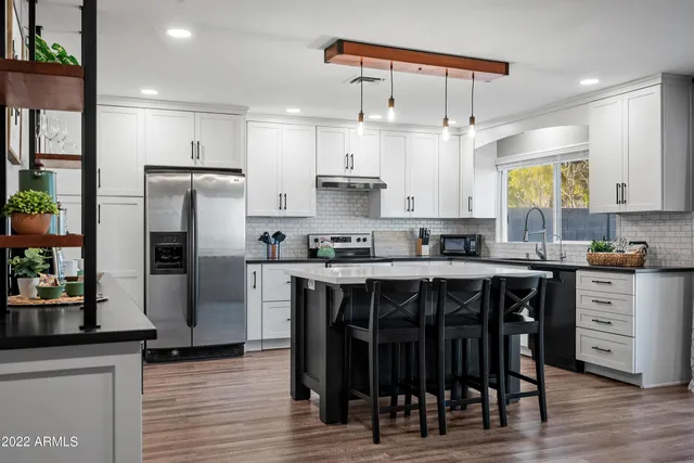 a kitchen with a refrigerator and a stove top oven