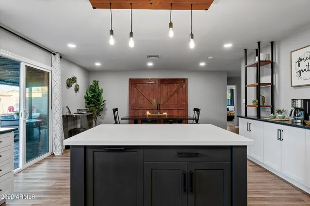 a large kitchen with kitchen island a sink table and chairs