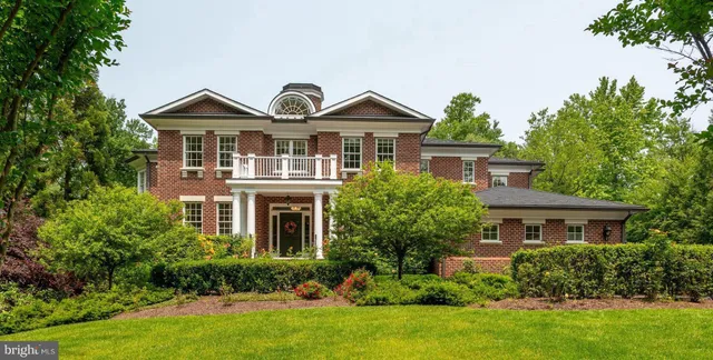 a front view of a house with a yard and potted plants