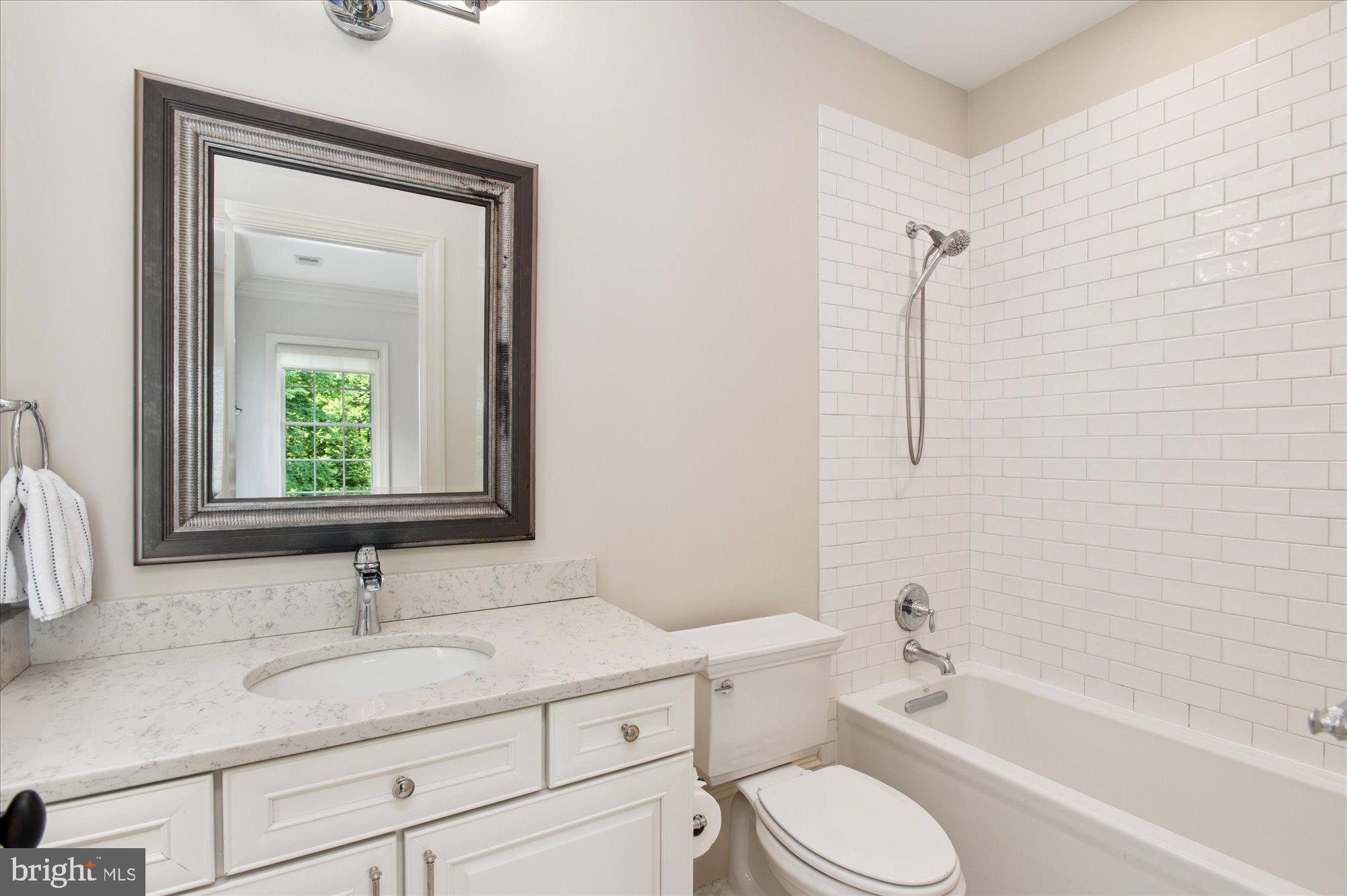 6804 Benjamin Street McLean, VA 22101 - Photo 48 of 68 a bathroom with a granite countertop toilet sink and mirror