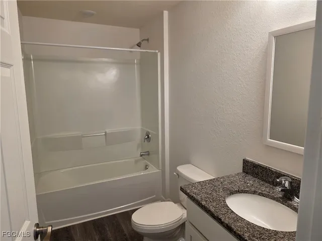 a bathroom with a granite countertop toilet sink and shower