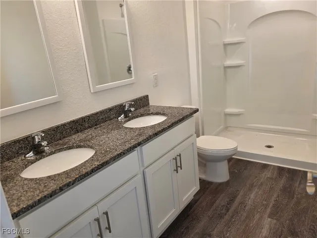 a bathroom with a granite countertop toilet sink and mirror