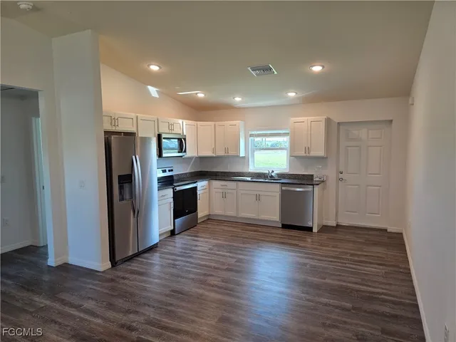 a kitchen with a refrigerator a sink and cabinets