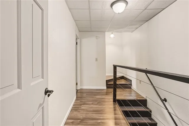 a view of a hallway with wooden floor and staircase