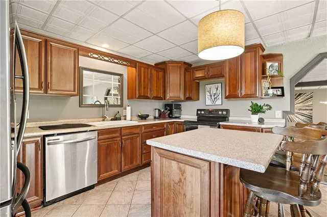a kitchen with stainless steel appliances granite countertop a stove a sink a microwave and a refrigerator