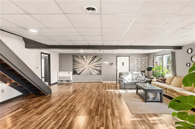 a living room with furniture a wooden floor and window