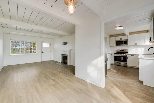 a view of kitchen with microwave a stove and wooden floor