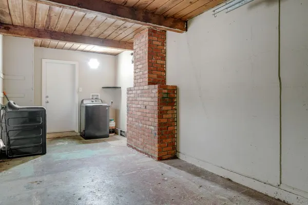 a view of an empty room with furniture and a window