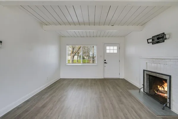 a view of an empty room with a fireplace and a window