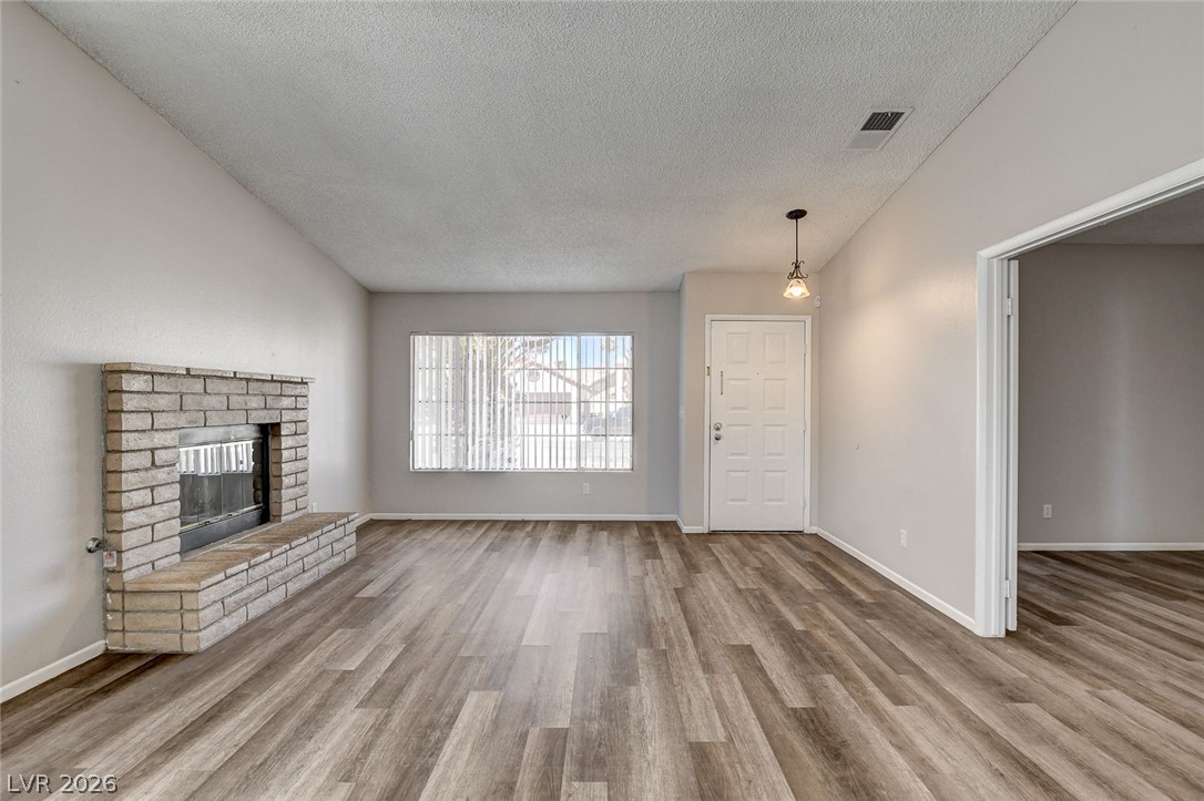6209 Warm River Road Las Vegas, NV 89108 - Photo 10 of 39 An inviting interior with wide plank flooring and a cozy fireplace creates a warm living space.
