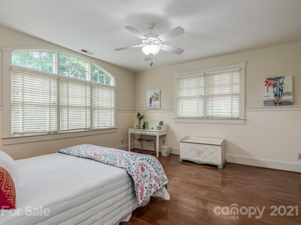 4608 Nora's Path Road Charlotte, NC 28226 - Photo 29 of 39 a spacious bedroom with a large bed and a chandelier