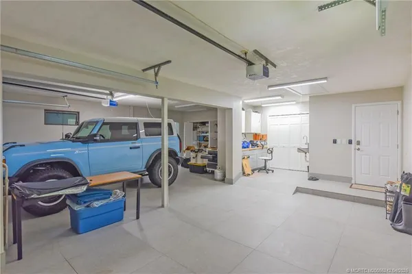 a view of an empty room with wooden floor and fence