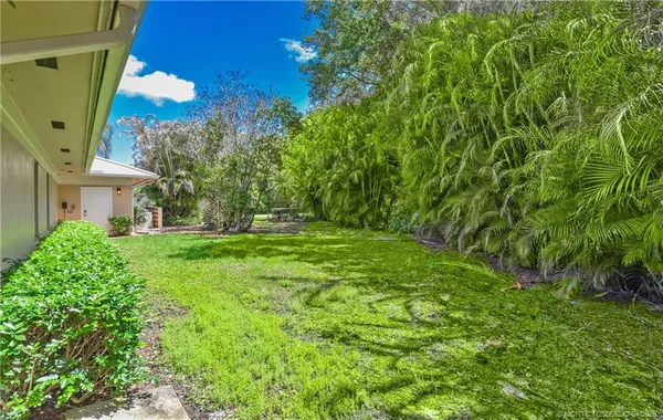 an aerial view of a house with a garden and lake view