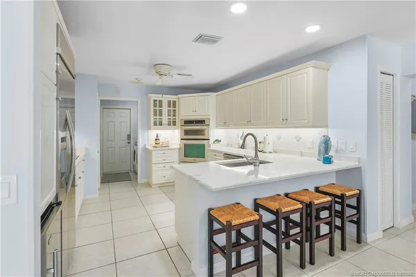 a dining hall with stainless steel appliances granite countertop a dining table and chairs