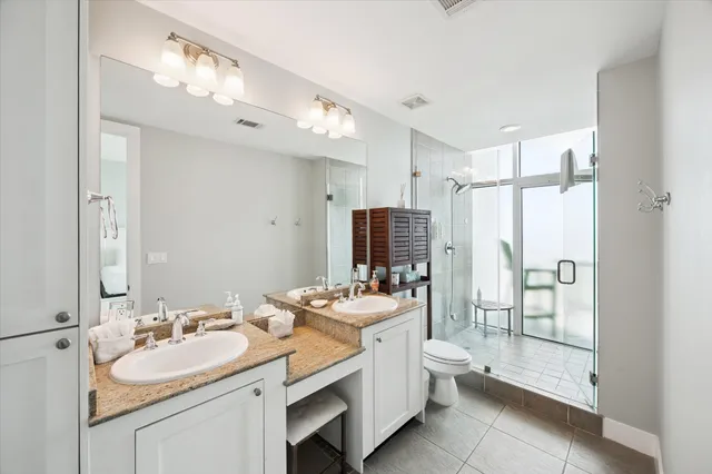 a bathroom with a double sink double vanity mirror and a shower