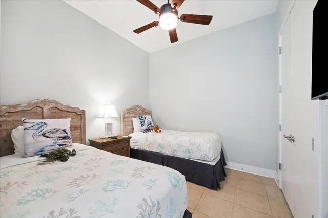 a bedroom with two beds and ceiling fan