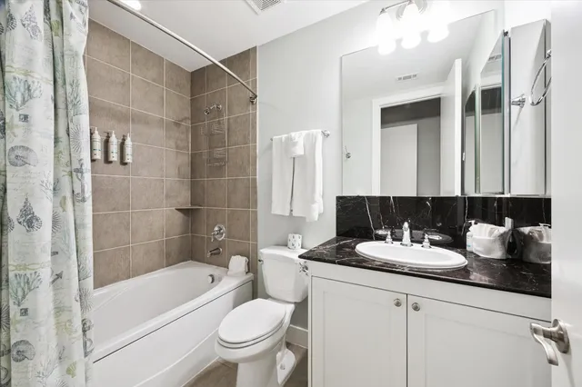 a bathroom with a tub sink toilet and mirror