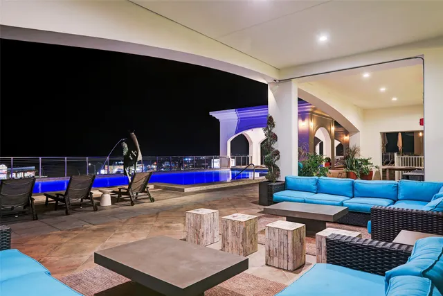 a living room with blue lights with furniture and a flat screen tv