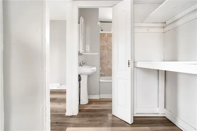 a bathroom with a sink and mirror with bathtub