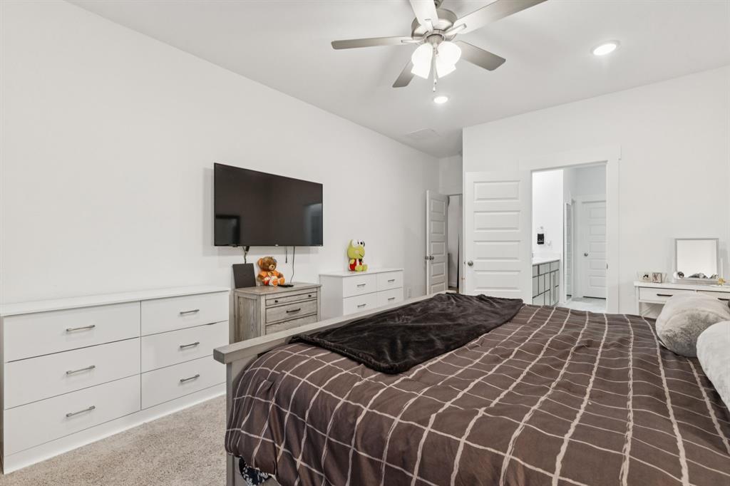 1238 Beaumont Lane Red Oak, TX 75154 - Photo 11 of 29 a bedroom with a large bed and a flat tv screen on dresser