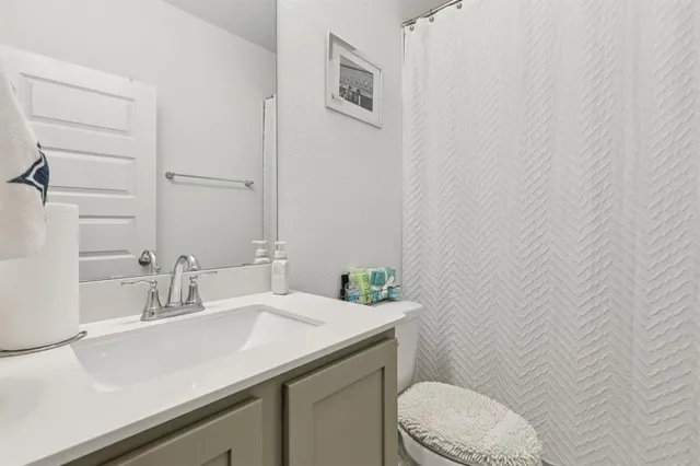 a bathroom with a sink a toilet and a mirror