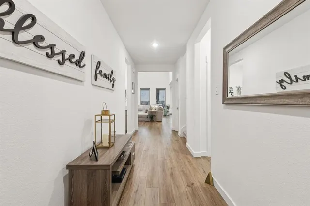 a view of a hallway with wooden floor and staircase
