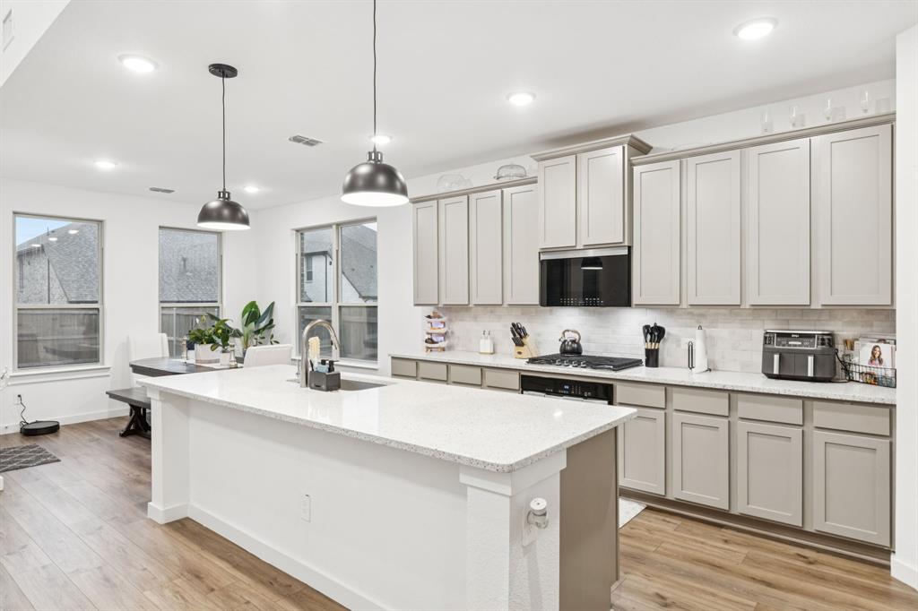 1238 Beaumont Lane Red Oak, TX 75154 - Photo 6 of 29 a kitchen with stainless steel appliances kitchen island a sink a stove and cabinets