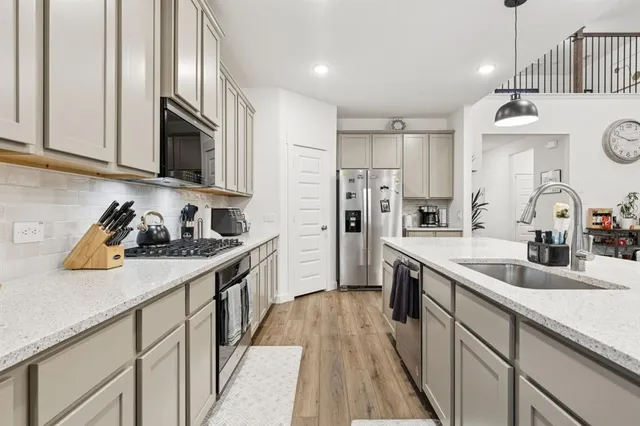 a kitchen with stainless steel appliances granite countertop a sink stove and refrigerator
